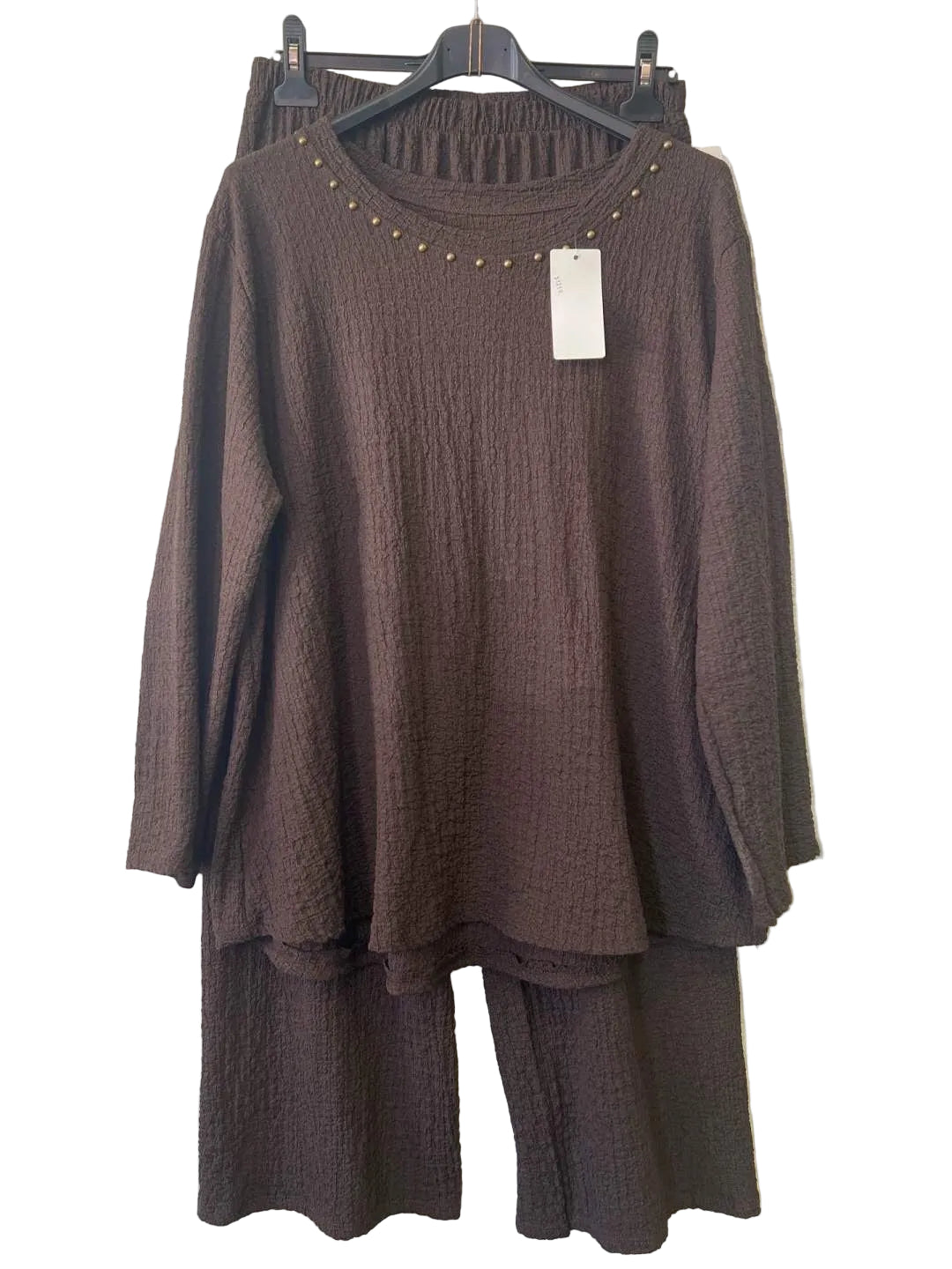 A dark brown two-piece matching set featuring a textured long-sleeve tunic top with gold stud detailing around the neckline and matching textured wide-leg pants