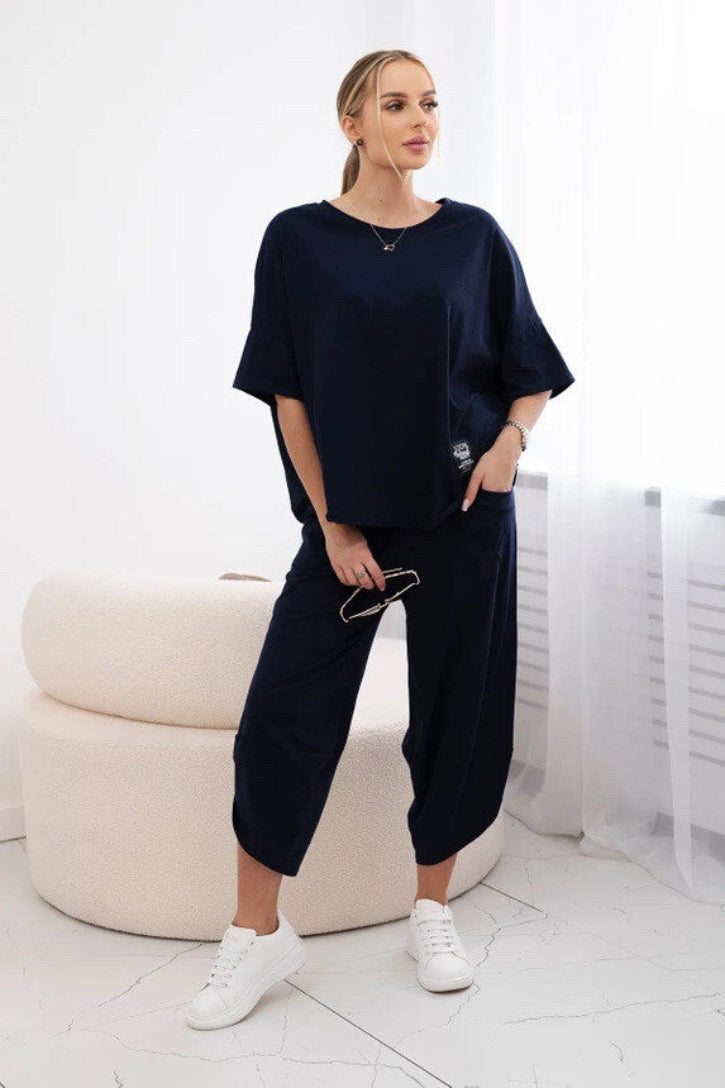 Woman wearing a navy blue outfit in a minimalistic room.
