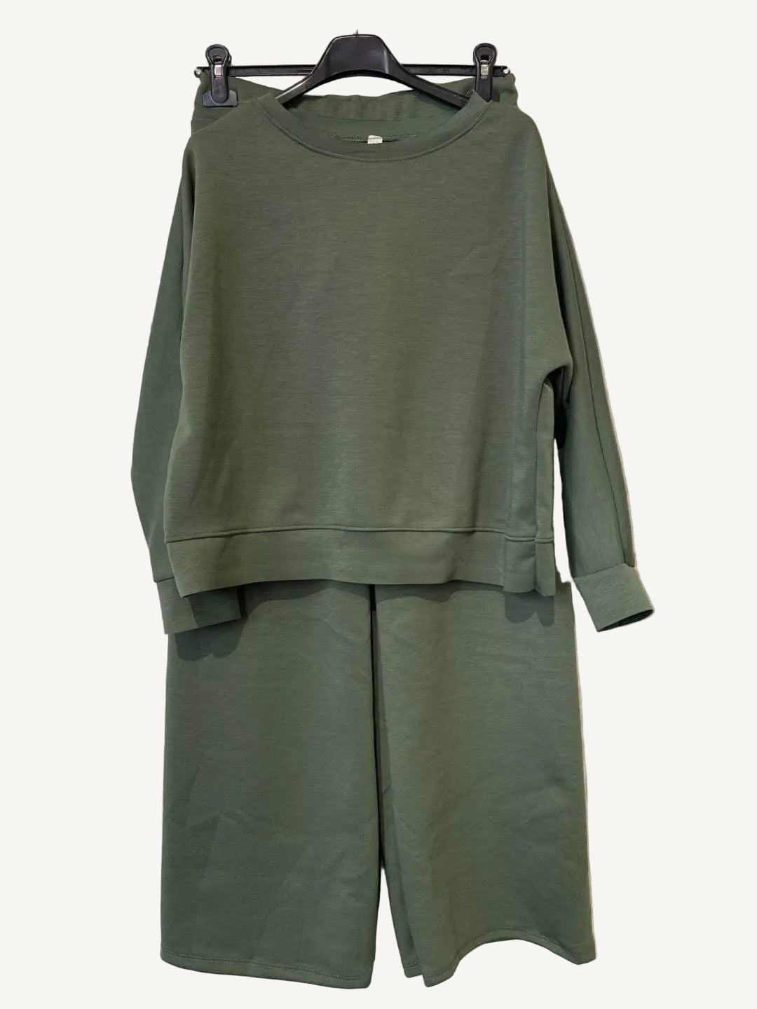 Green outfit with a sweatshirt and pants on a hanger 