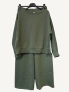 Green outfit with a sweatshirt and pants on a hanger 