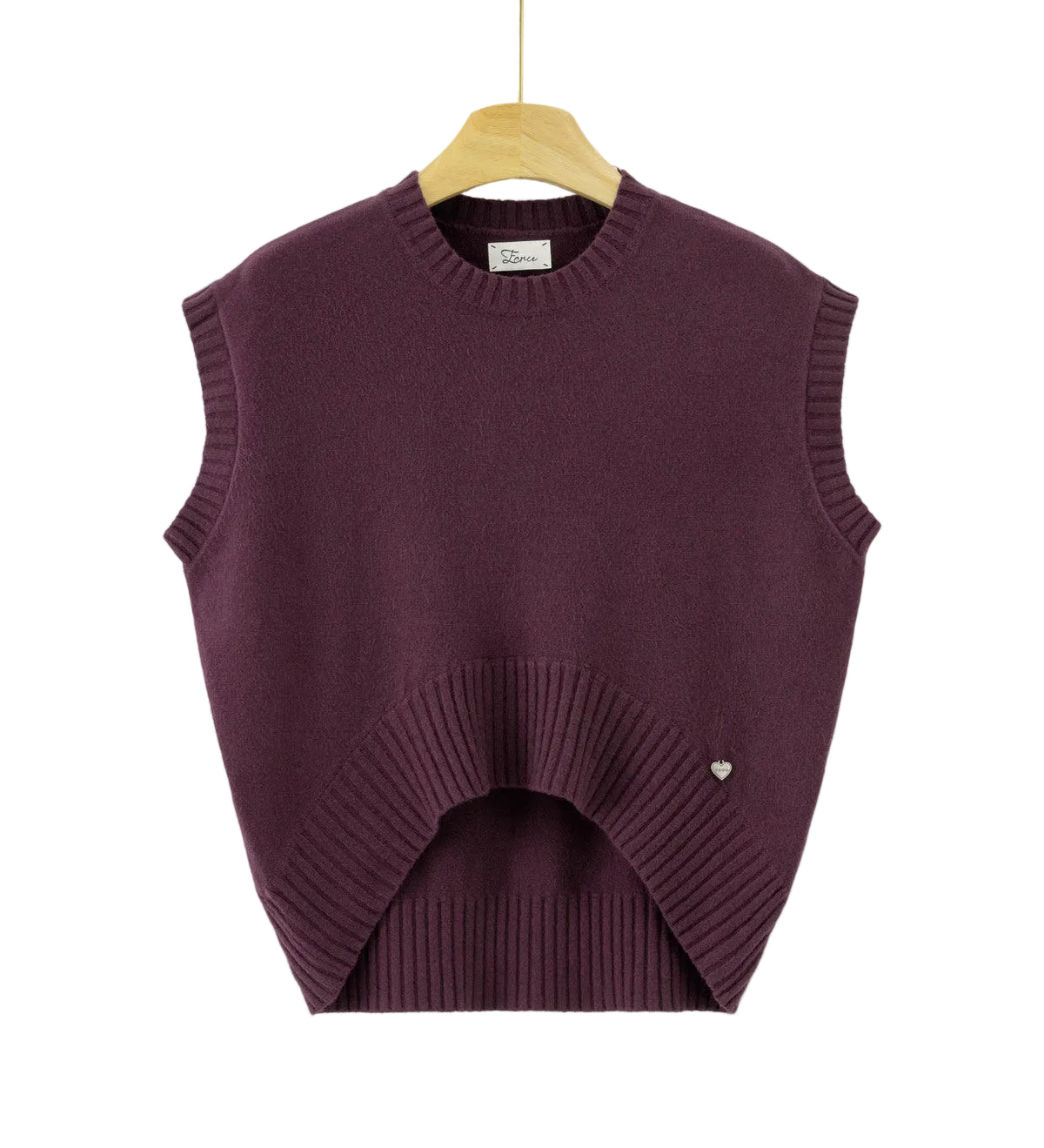 A sleeveless crewneck knit sweater vest in deep plum purple, hanging on a wooden hanger against a plain white background. The vest features a curved hemline with ribbed detailing and a small silver heart charm on the lower right side.
