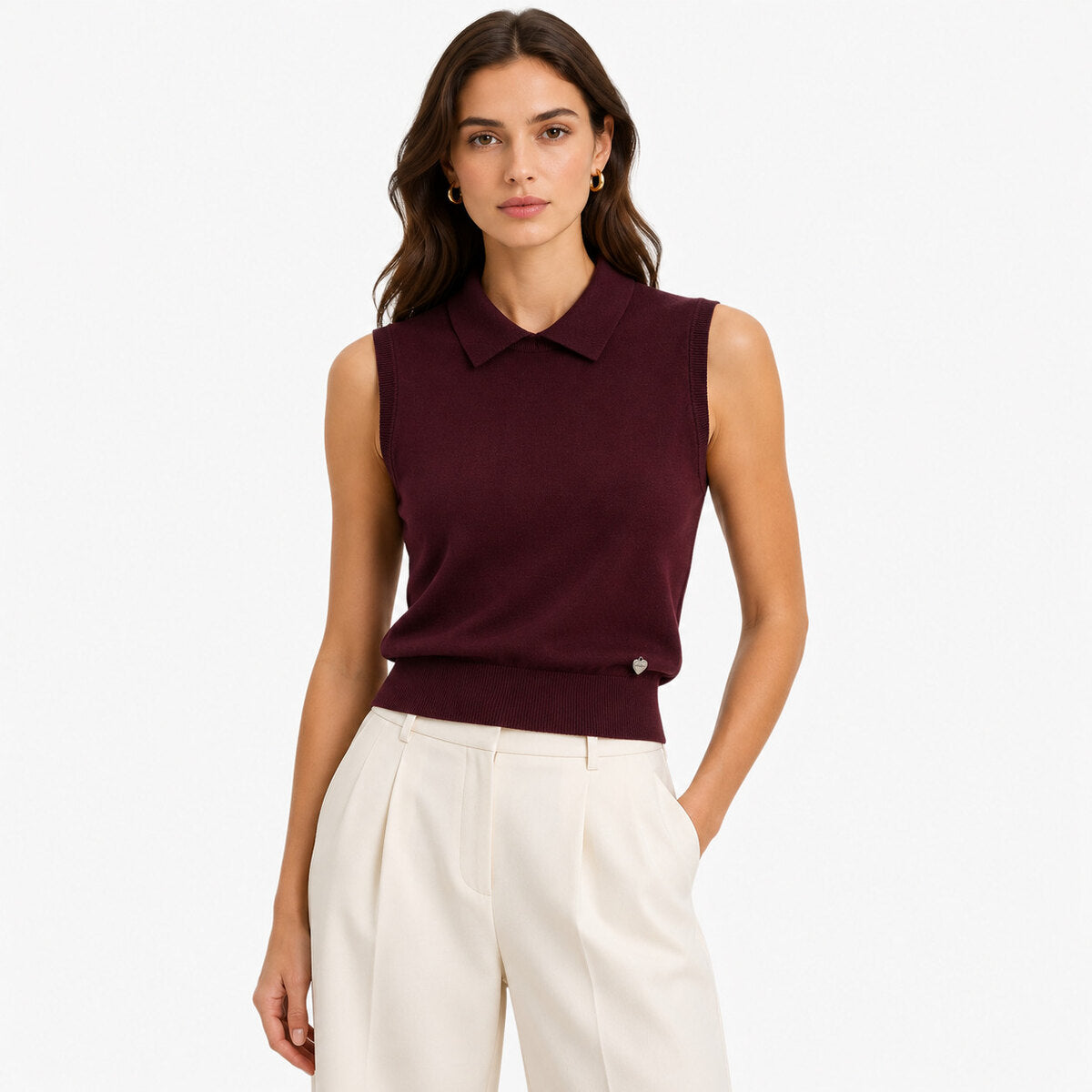 A woman modeling a sleeveless knit polo top in deep burgundy
