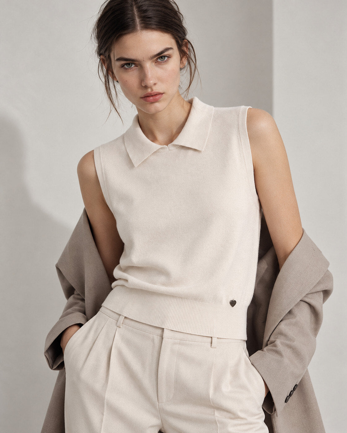 Sleeveless sweater in ecru colour with collar and ribbed hem