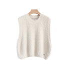 An off-white textured knit sweater vest hanging on a wooden hanger against a white background,