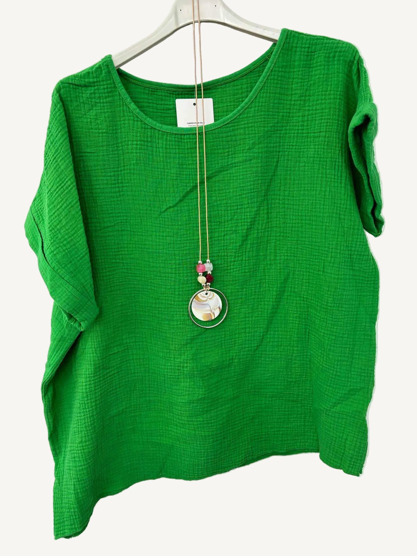 Green top with a necklace on a white background