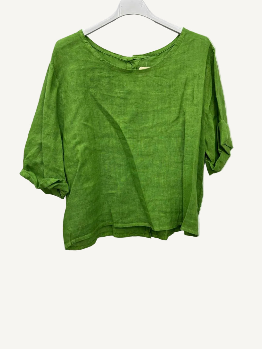 Green shirt on a hanger against a white background