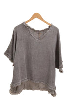 Grey top on a hanger against a white background