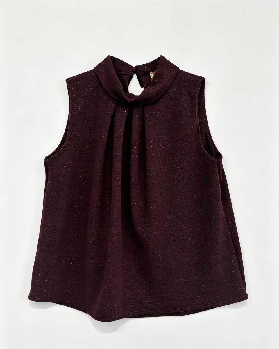 A sleeveless dark burgundy top with a high gathered mock neck and front pleats, laid flat against a light off-white background.