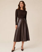 A woman modeling a dark brown long-sleeve knit top and a matching dark brown leather midi skirt 