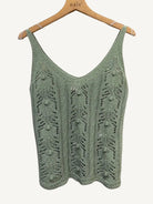 Green knitted vest on a hanger 