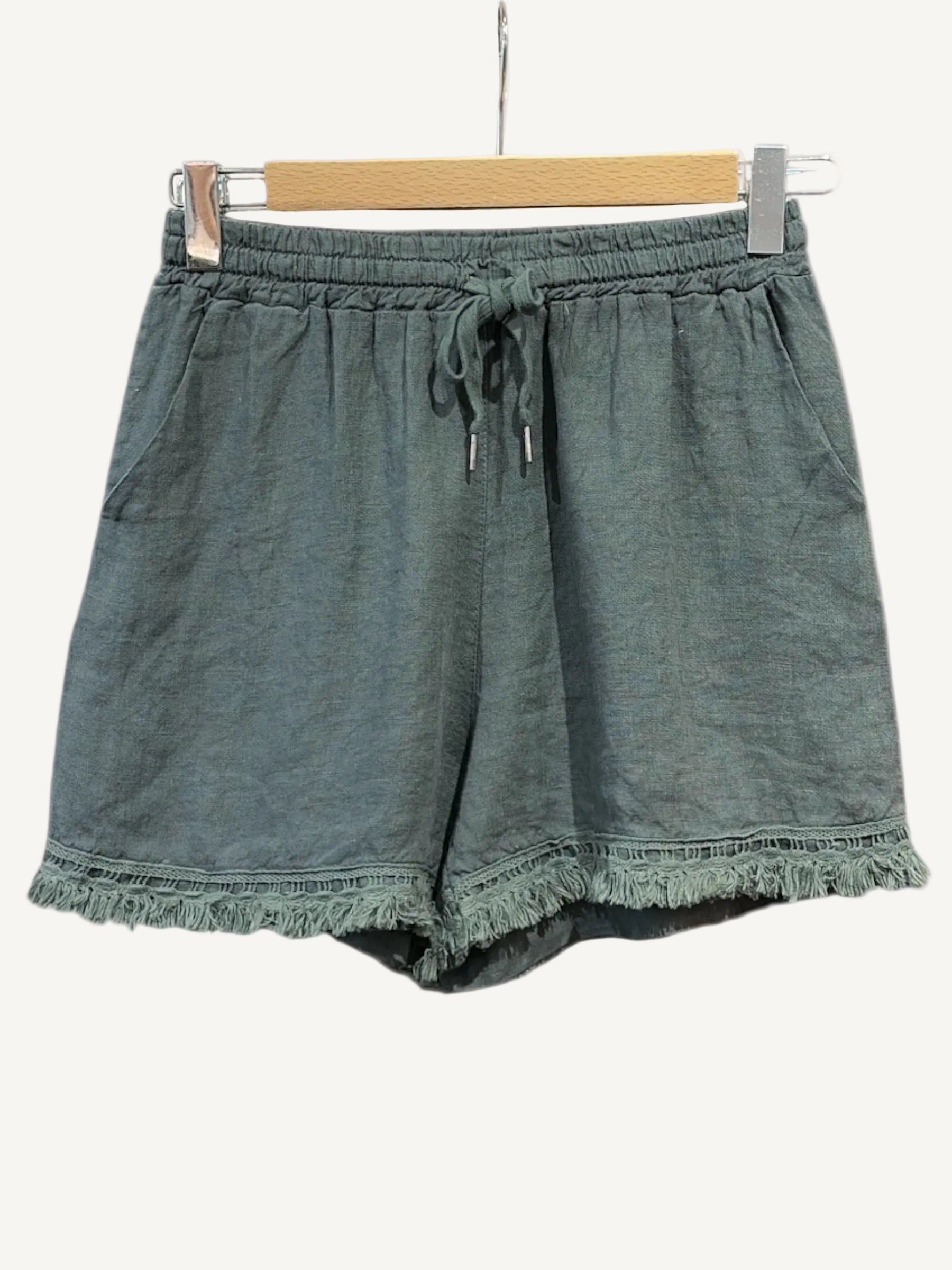 Green shorts with frayed hem on a white background