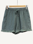 Green shorts with frayed hem on a white background