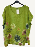 Lime Green floral top on a hanger against a textured white background