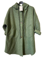 An olive green textured hooded coat with a button-front closure, large front patch pockets, and rolled cuffs, hanging on a black hanger against a light gray patterned backdrop.