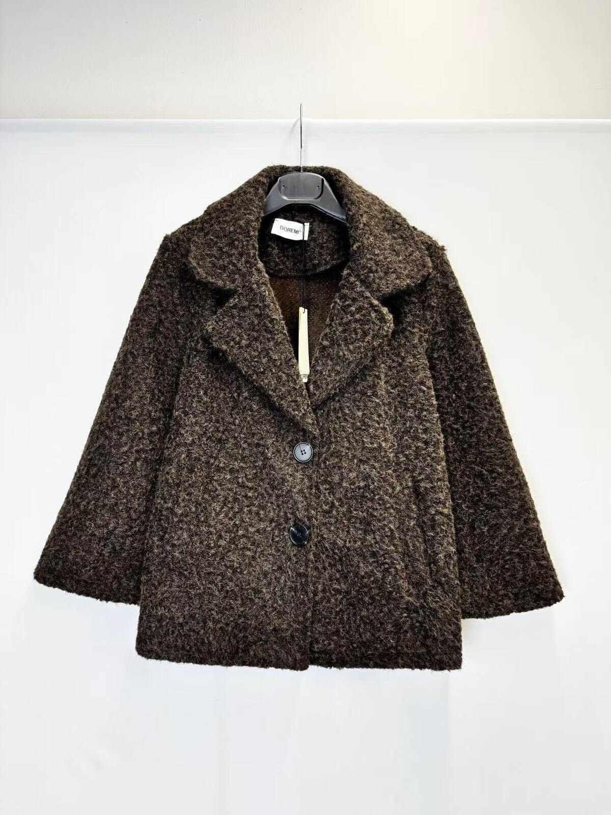A brown textured bouclé coat with a single button closure, hanging on a black hanger against a plain white background.