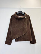 A brown textured wrap jacket with a high mock neck and asymmetrical button detail, hanging on a black hanger against a plain white wall.