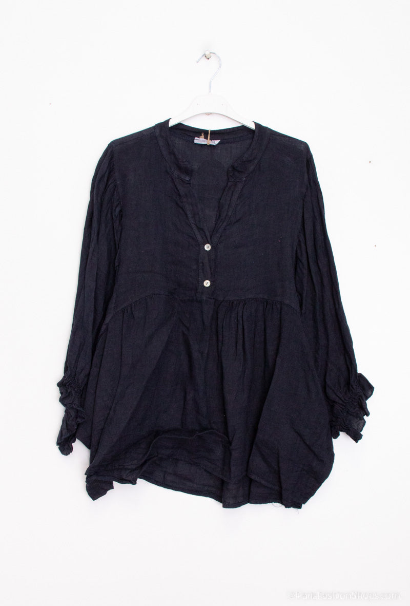 navy blouse on a hanger against a white background