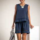 A woman models a sleeveless navy blue top with matching shorts