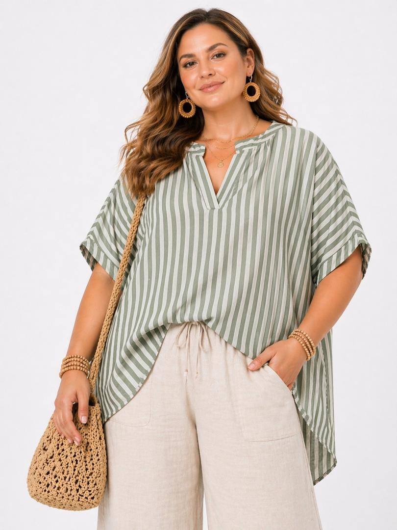Woman wearing a green and white striped shirt with beige pants, holding a woven bag on a white background
