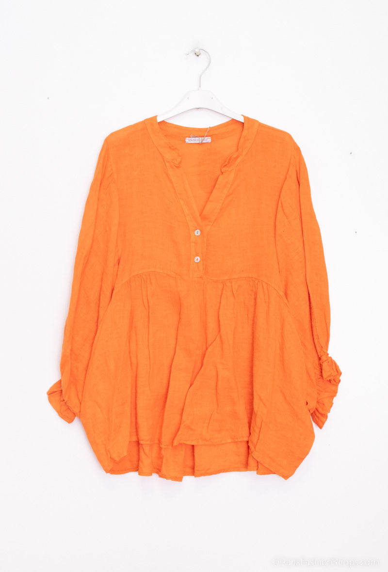 Orange blouse on a hanger against a white background