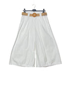 White wide-leg pants with a brown belt on a hanger against a plain background