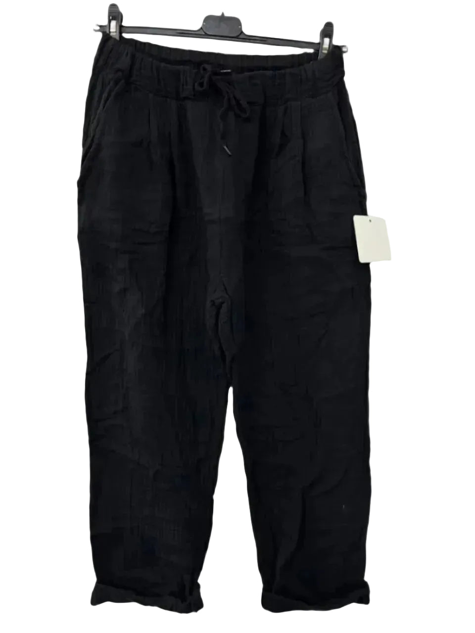 Black cotton gauze trousers with elasticated drawstring waist, displayed on a hanger.