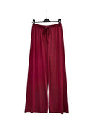 A pair of wide-leg knit pants in a deep burgundy red