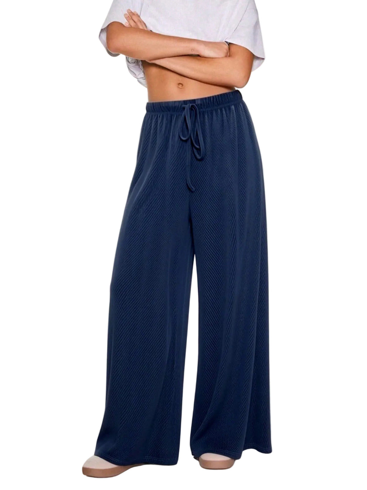 A person wearing loose, wide-leg navy lounge pants with a drawstring waist