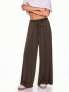 A model wearing dark brown wide-leg drawstring pants