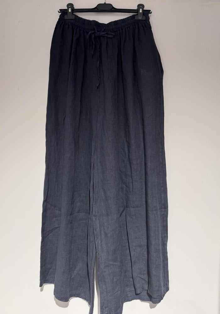 Dark blue pants on a hanger against a white background