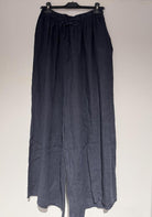 Dark blue pants on a hanger against a white background