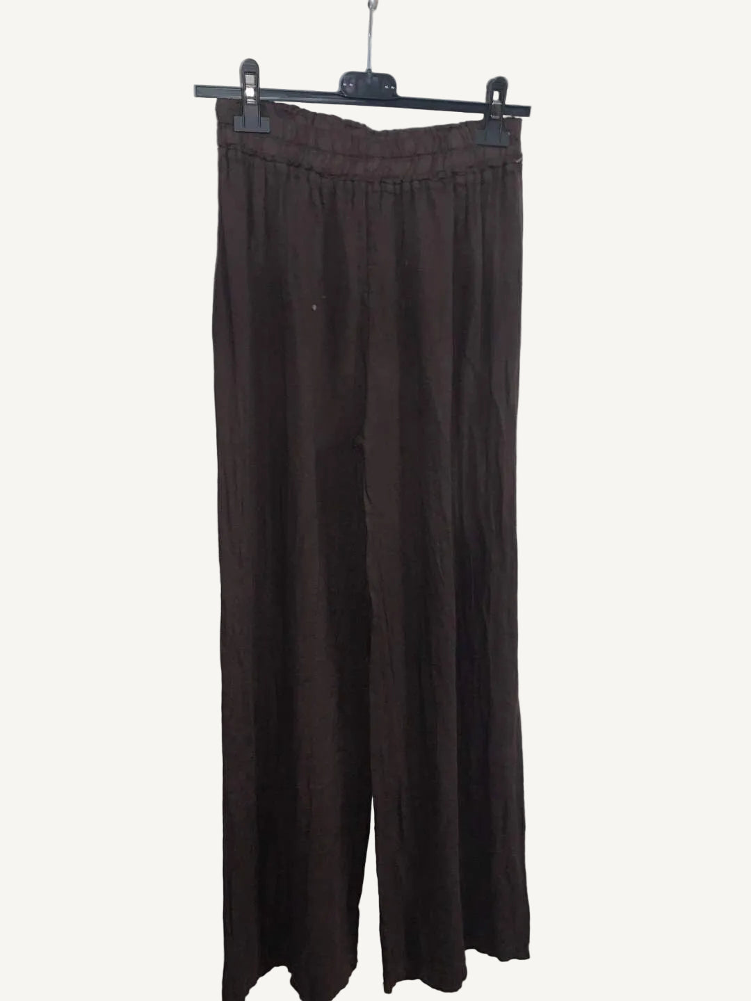 Brown pants hanging against a plain white wall