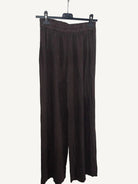 Brown pants hanging against a plain white wall