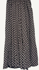 Brown trousers with white polka dot pattern on a plain background