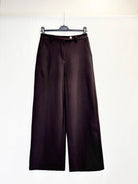 Dark brown wide-leg trousers hanging on a black hanger against a plain white background.