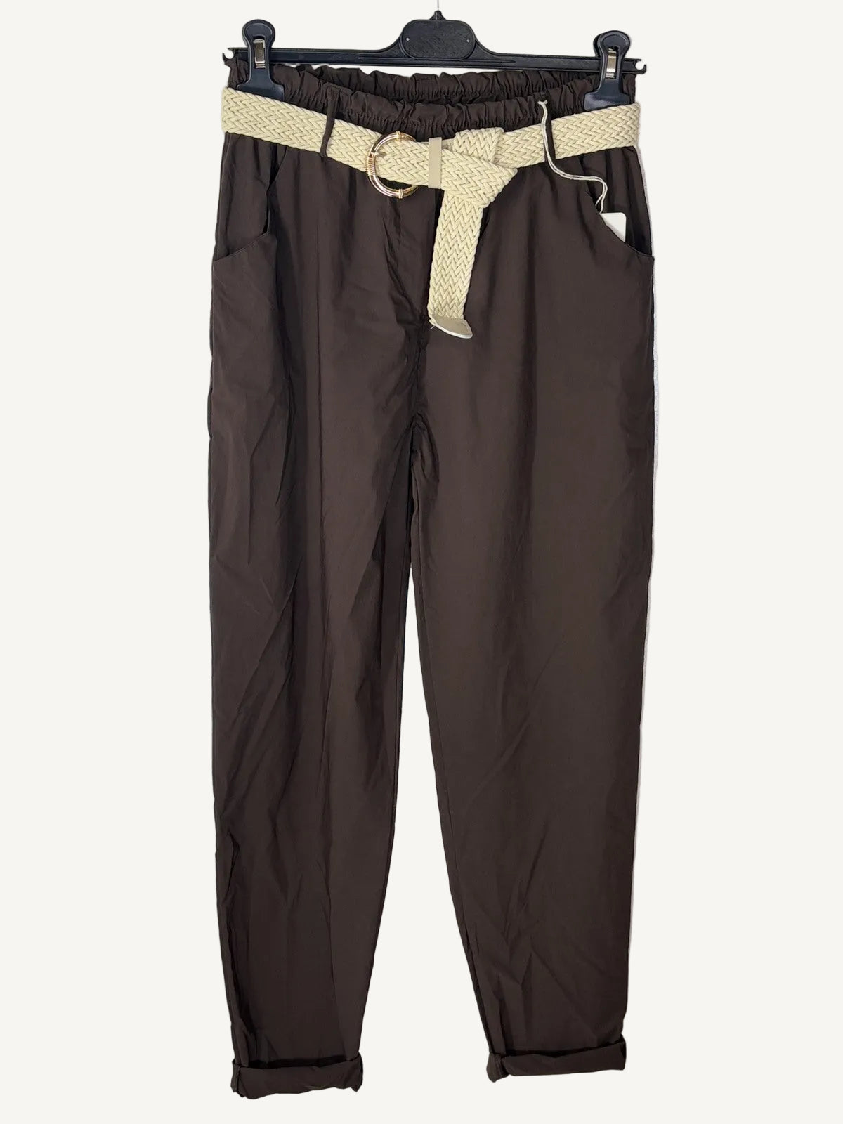 Brown pants with a beige belt on a textured surface