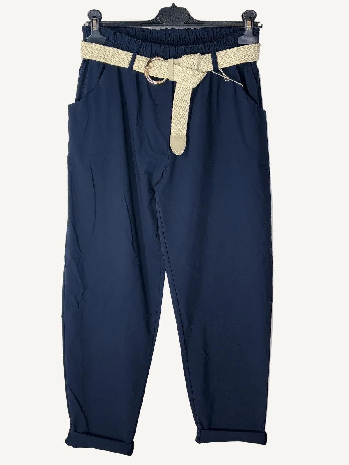 Navy blue pants with a beige belt on a textured white background