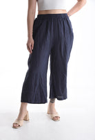 Person wearing navy wide-leg pants on a white background