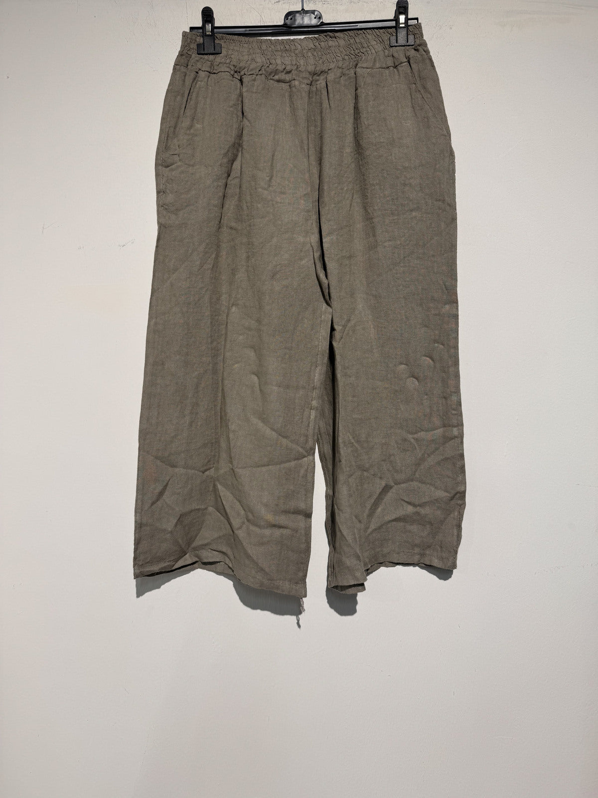 Brown wide-leg pants on a hanger against a white background