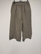 Brown wide-leg pants on a hanger against a white background