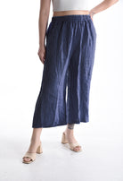 Person wearing blue wide-leg pants on a white background