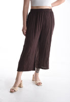 Brown wide-leg pants worn by a person on a white background