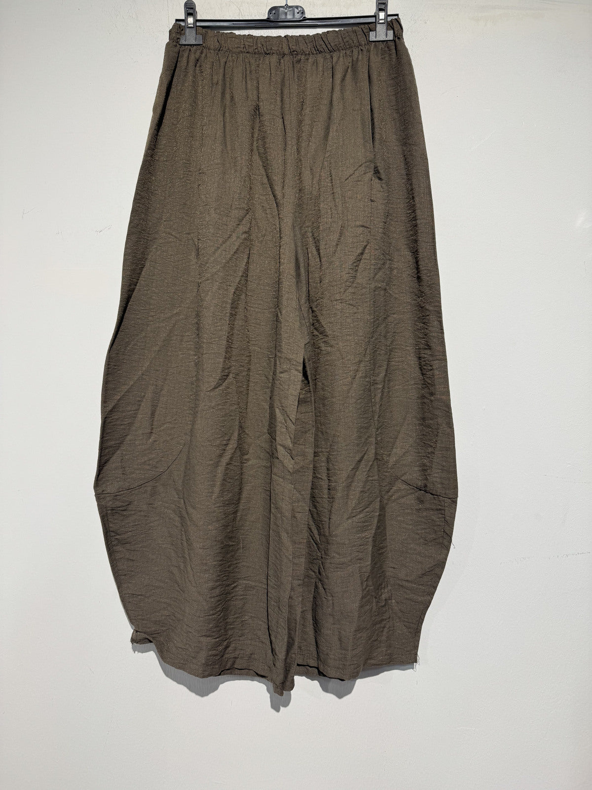 Brown pants hanging on a rack against a white background