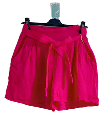 Pink shorts on a hanger against a white background