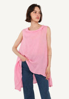 Woman wearing a pink sleeveless top and blue jeans on a white background