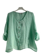 Pistachio shirt on a hanger against a white background