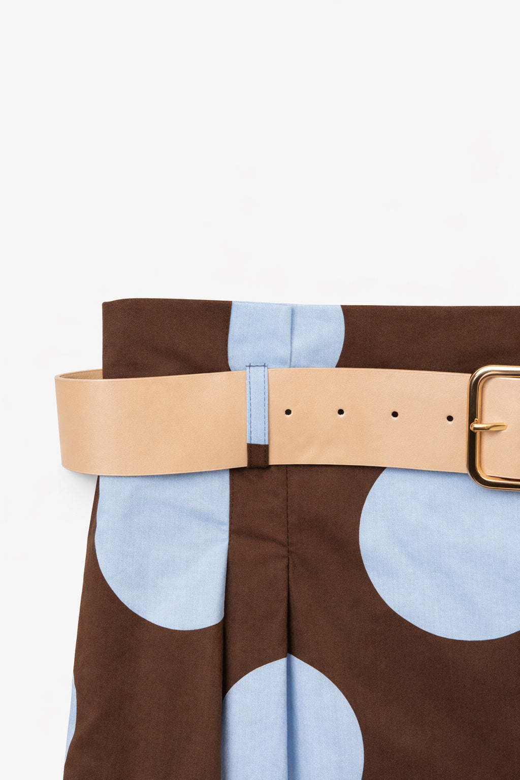 Close-up of a brown and blue polka dot dress with belt 