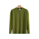 An olive green crewneck knit sweater hanging on a wooden hanger