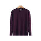 A dark purple long-sleeve knit sweater hanging on a wooden hanger