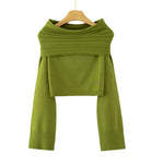 An olive green knit long-sleeve top with a wide draped yoke and cropped hem, hanging on a wooden hanger against a plain white background. 